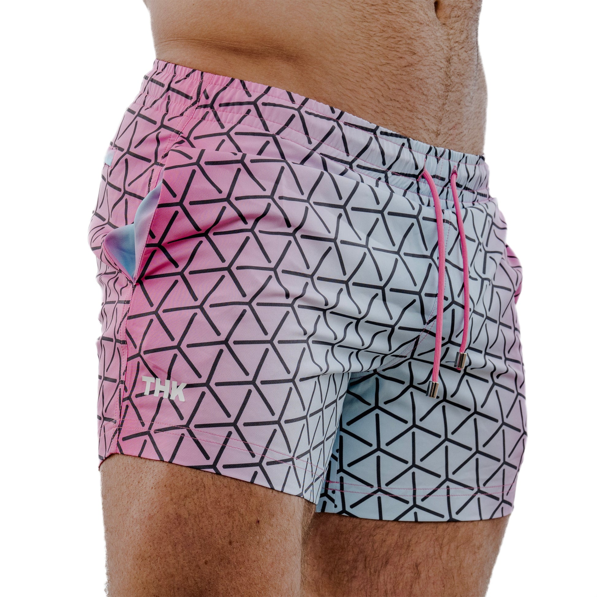 Geometric patterned swim shorts with pink drawstring on a white background