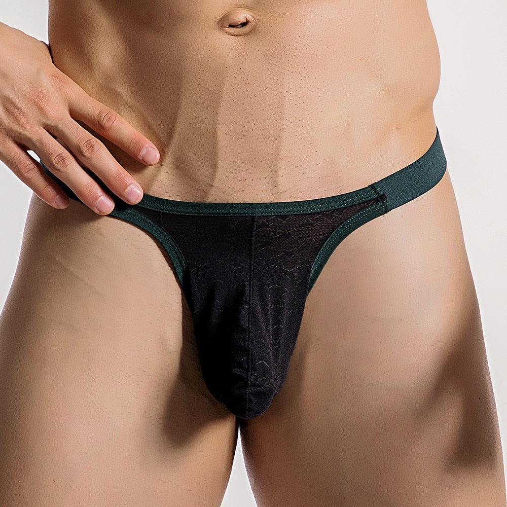 Black men's underwear with green waistband on a neutral background