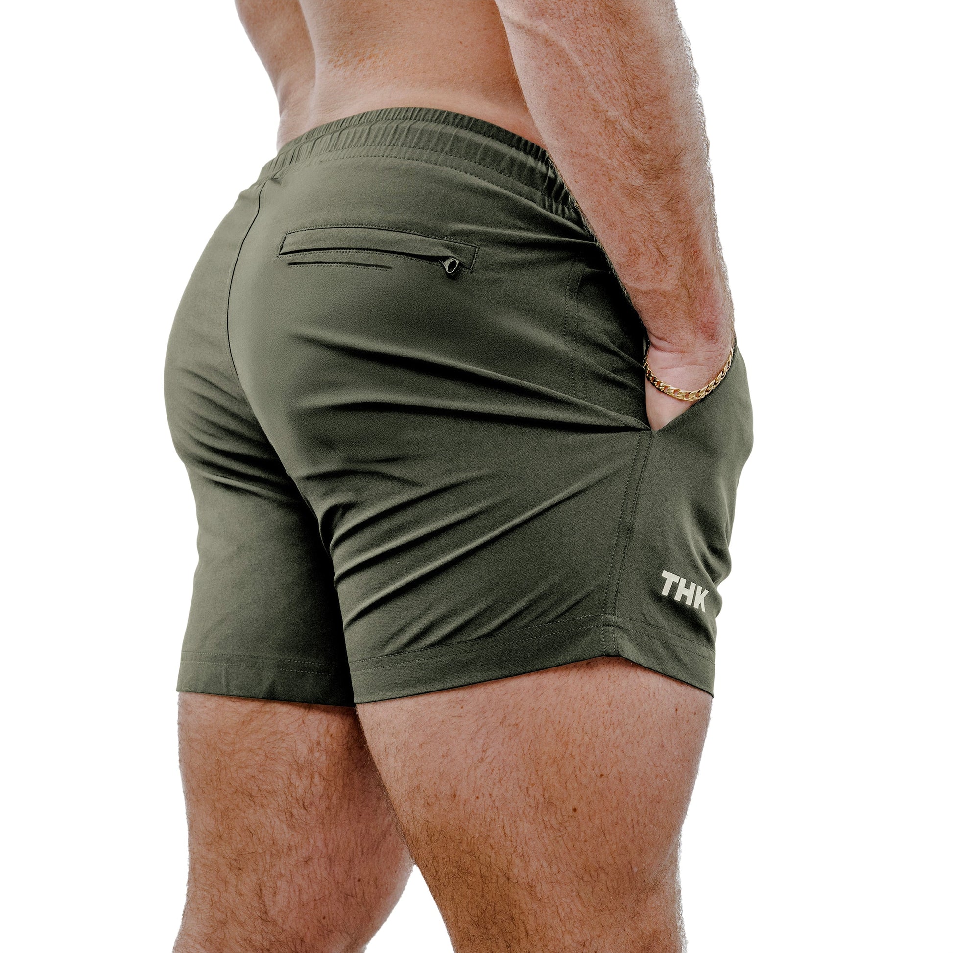 Man wearing sage green swim trunks on a white background