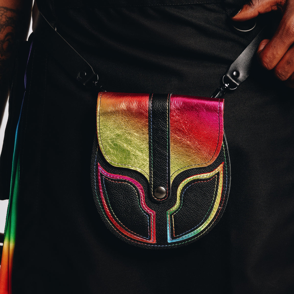 Multicolored leather pouch with an LGBTQ design attached to a black kilt.