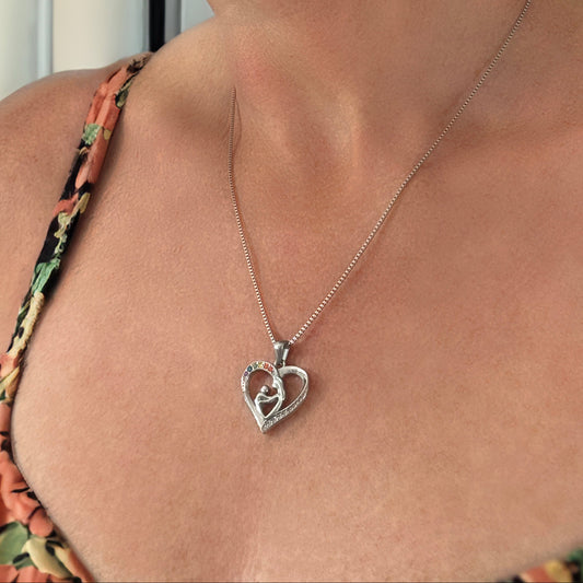 Woman wearing a floral top and a silver heart-shaped necklace.