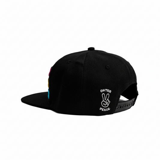 A black snapback cap shown from a three-quarter back angle on a white background, featuring a white embroidered 'OUTER PEACE' peace sign logo on the side and a colorful vertical stripe detail on the front edge.