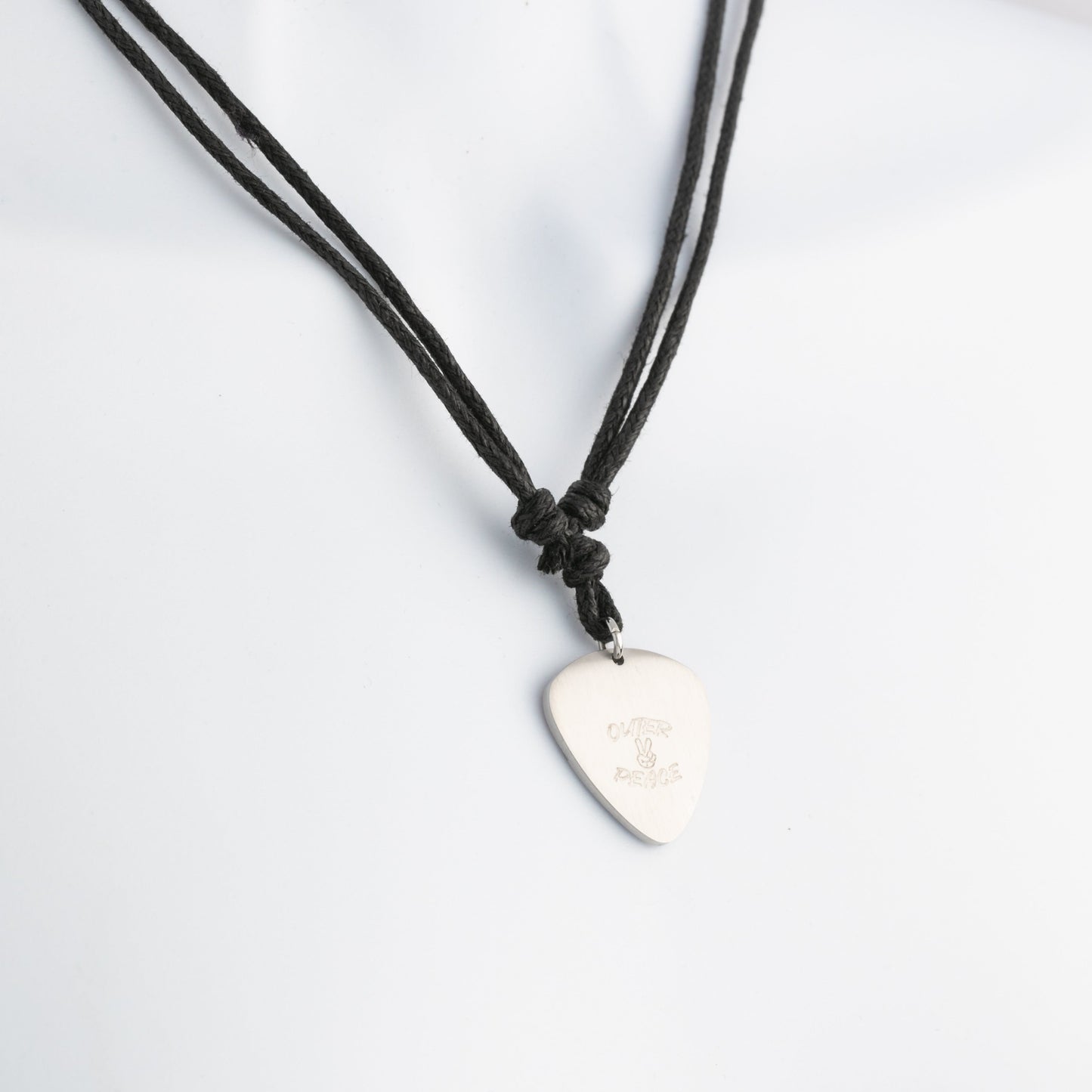Necklace with a guitar pick pendant on a white background