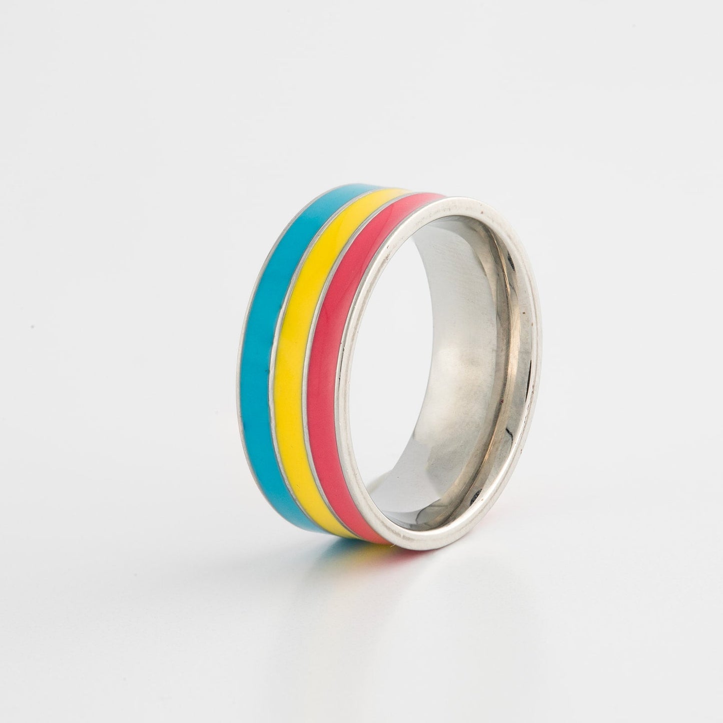 Ring with pan pride flag stripes on a light gray background