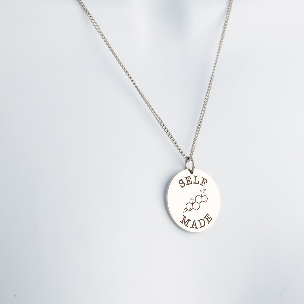 Silver necklace with a round pendant on a light gray background