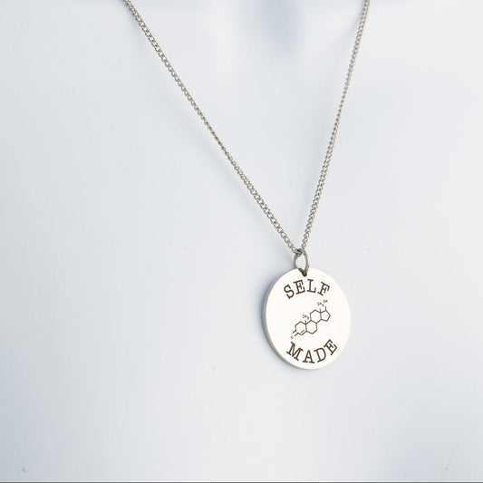 Silver necklace with a round pendant on a light gray background