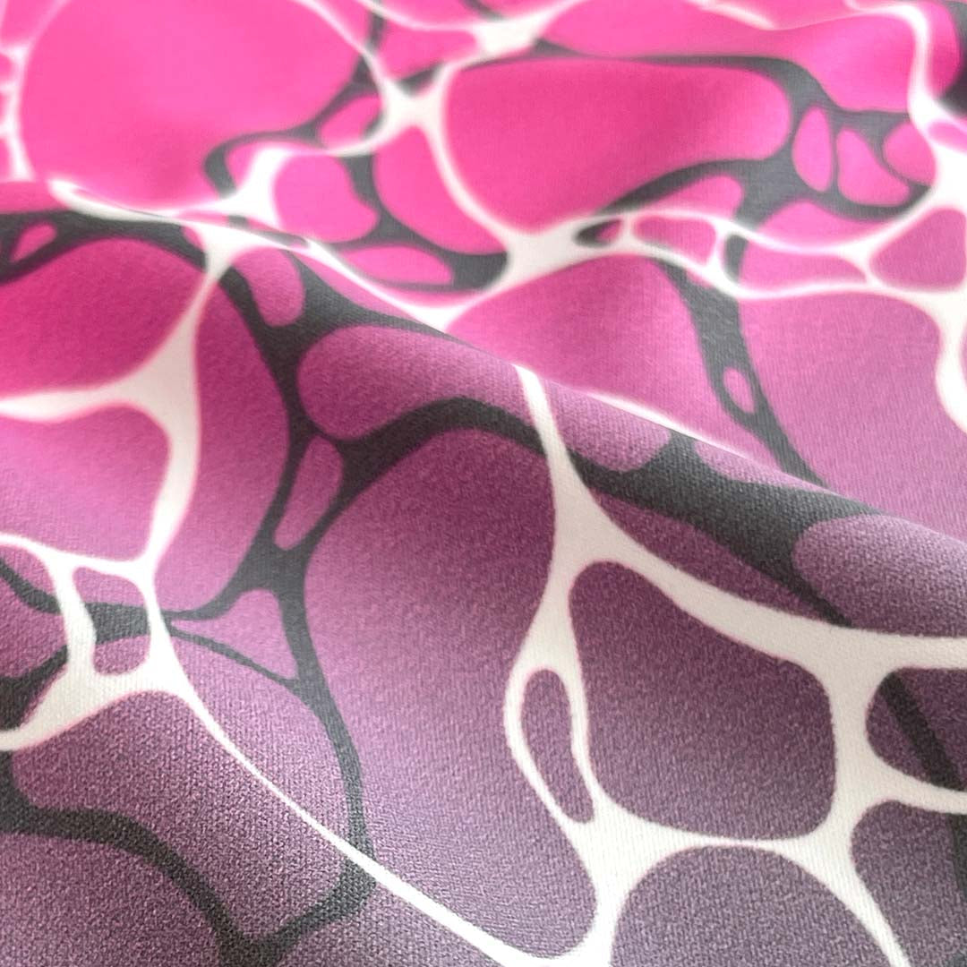 Close-up of fabric with pink, purple, and black abstract pattern