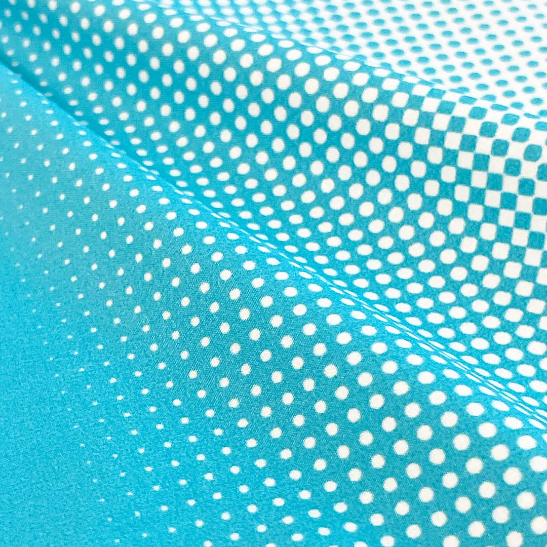 Turquoise fabric detail with white polka dot pattern