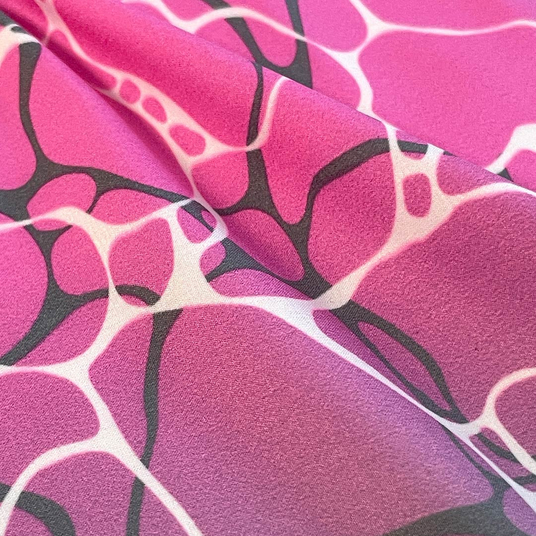 Close-up of pink fabric with black and white abstract pattern
