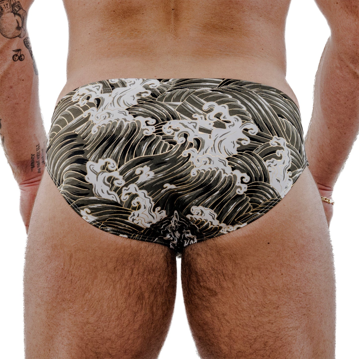 Person wearing a speedo with wave pattern on a plain background
