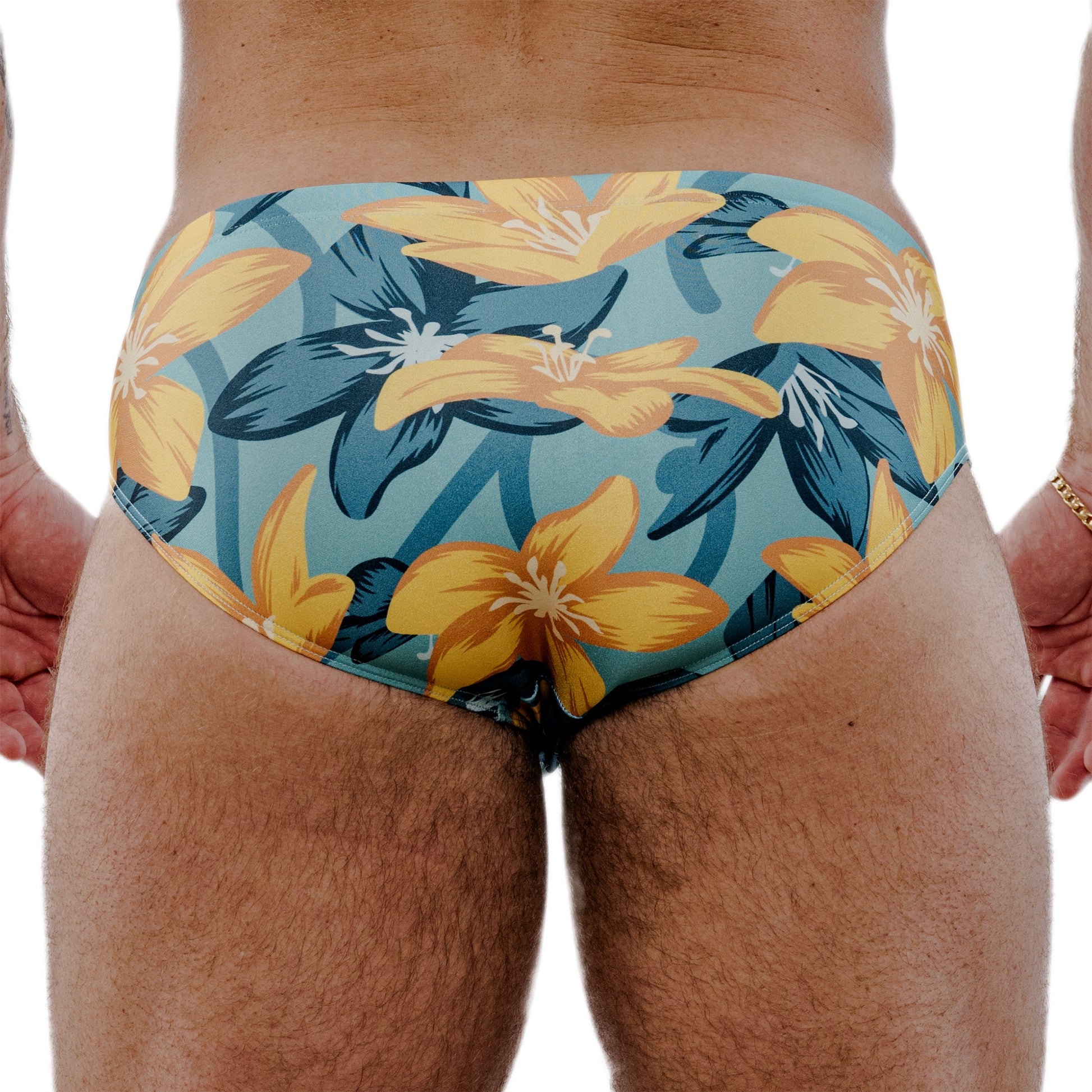 Floral-patterned swim briefs worn by a person on a white background