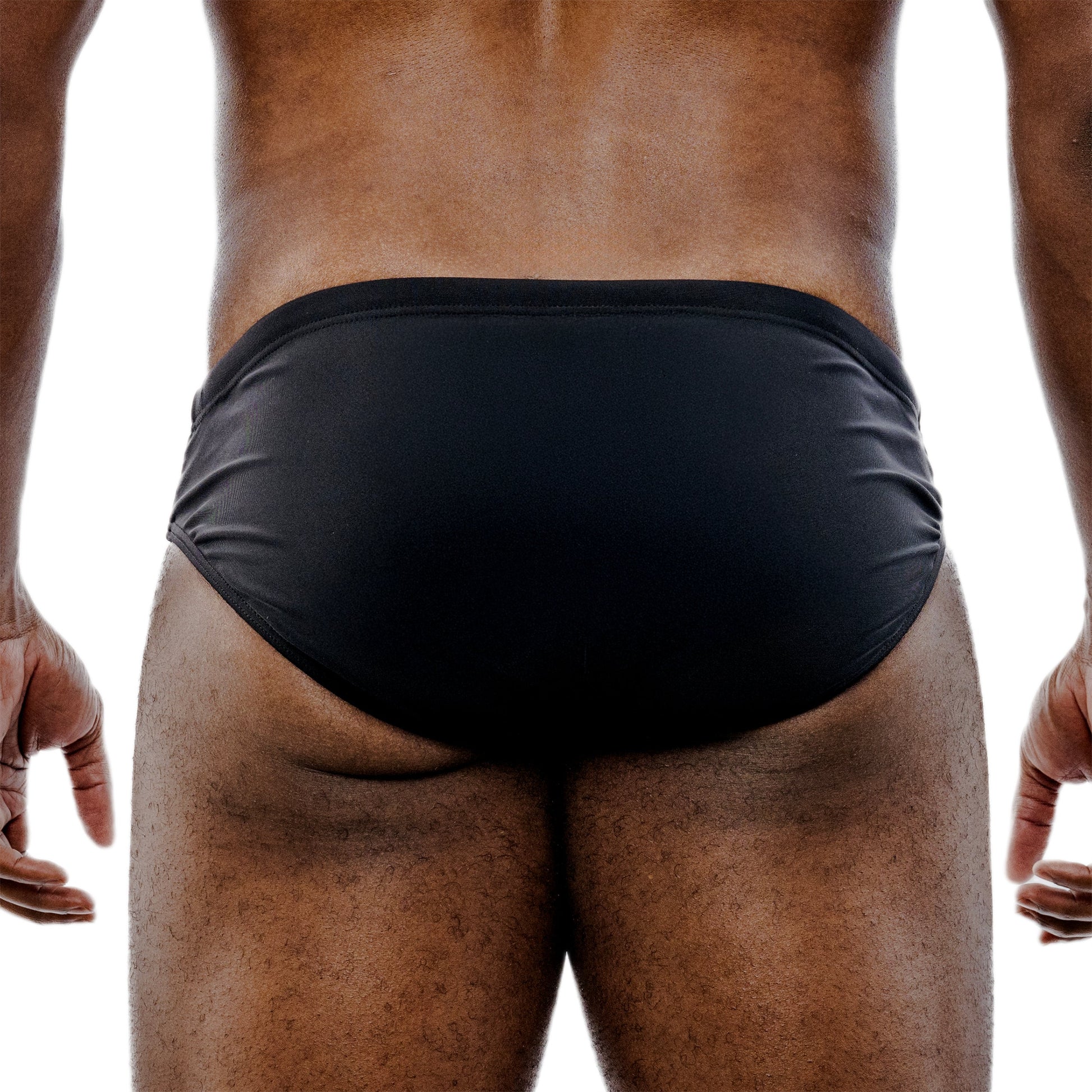 Black swim briefs worn by a person on a white background