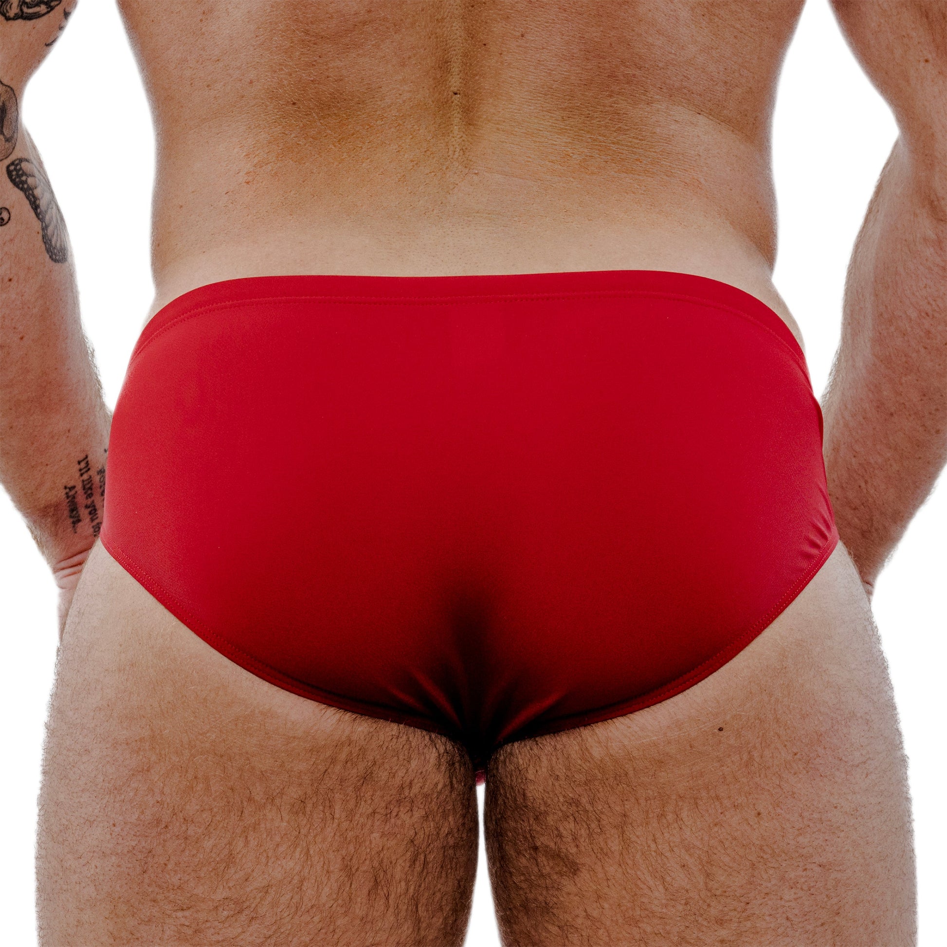 Red swim briefs worn by a person on a white background