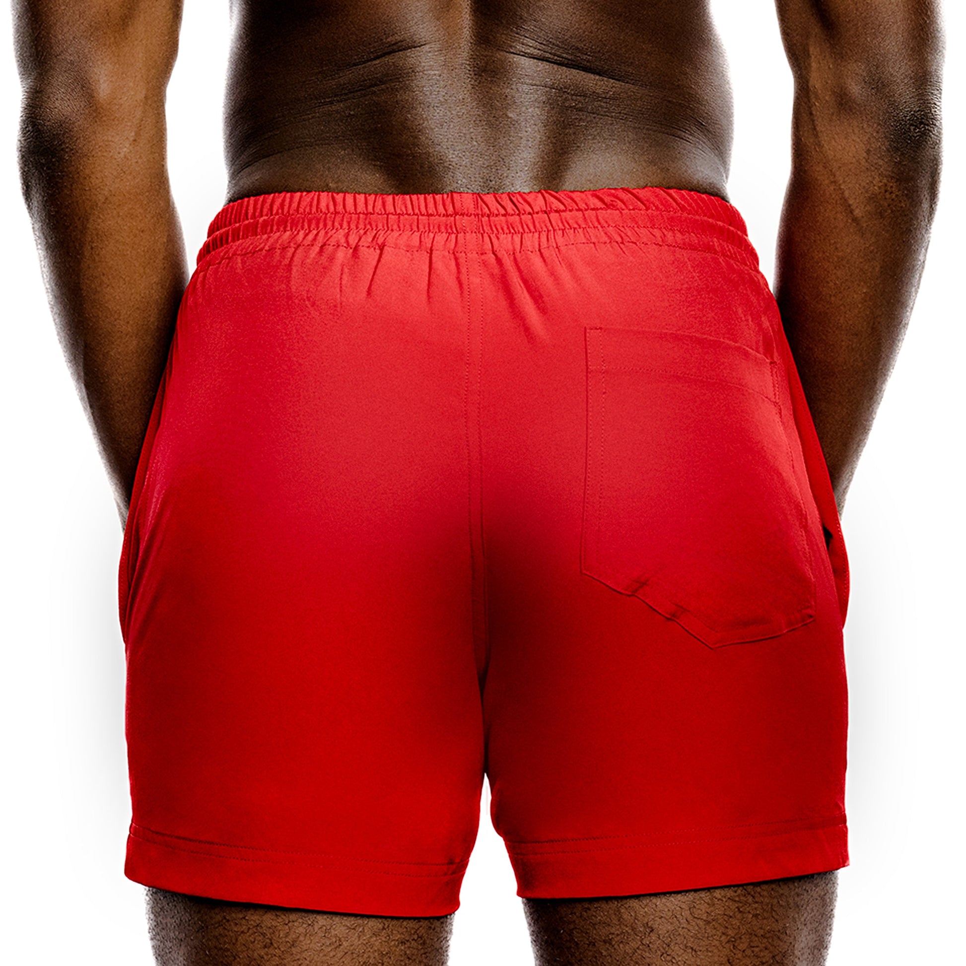 Red gym shorts worn by a person on a white background
