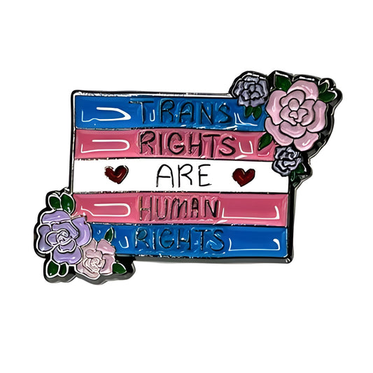 Pin with 'Trans Rights Are Human Rights' text and floral designs on a white background