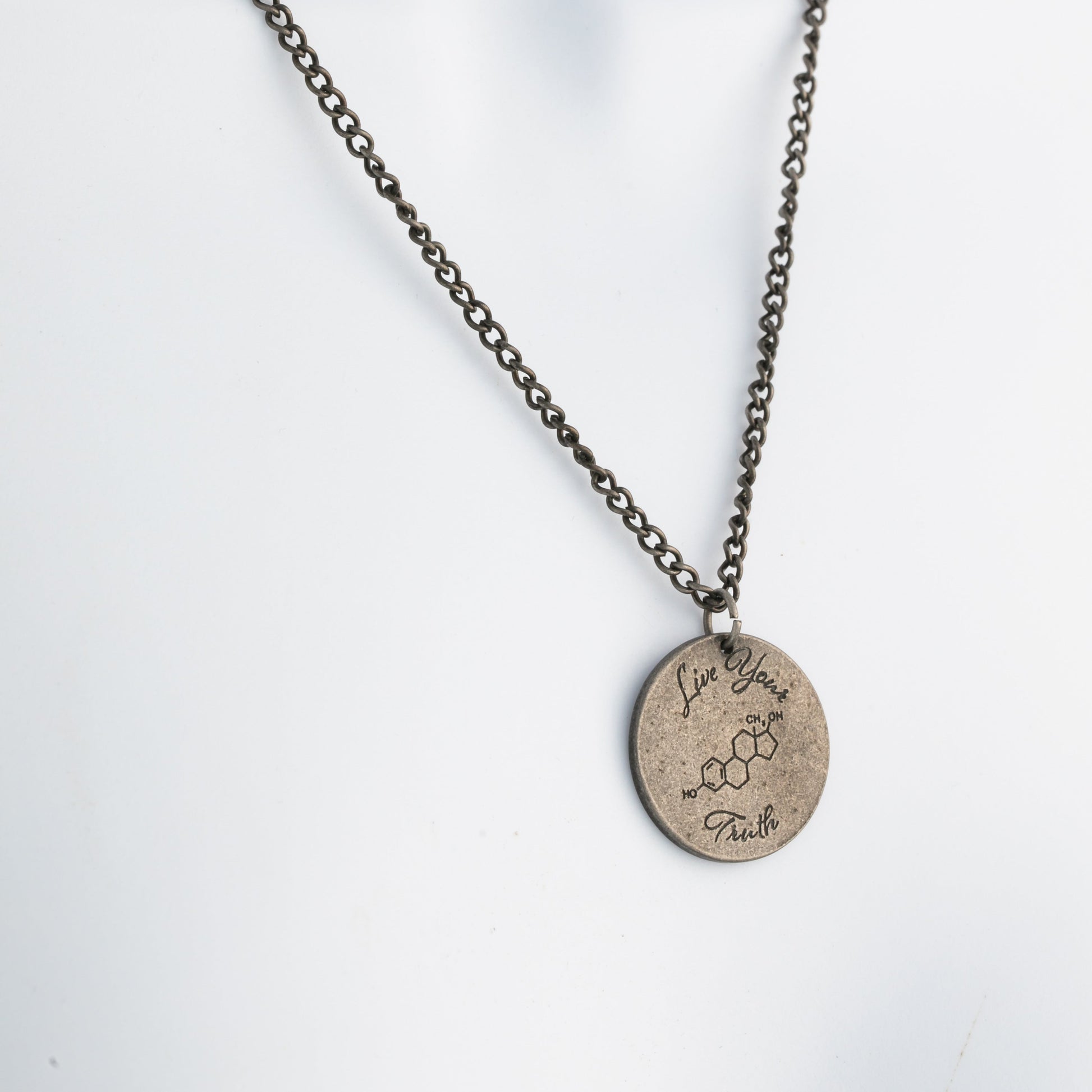 Necklace with a round pendant on a mannequin against a white background