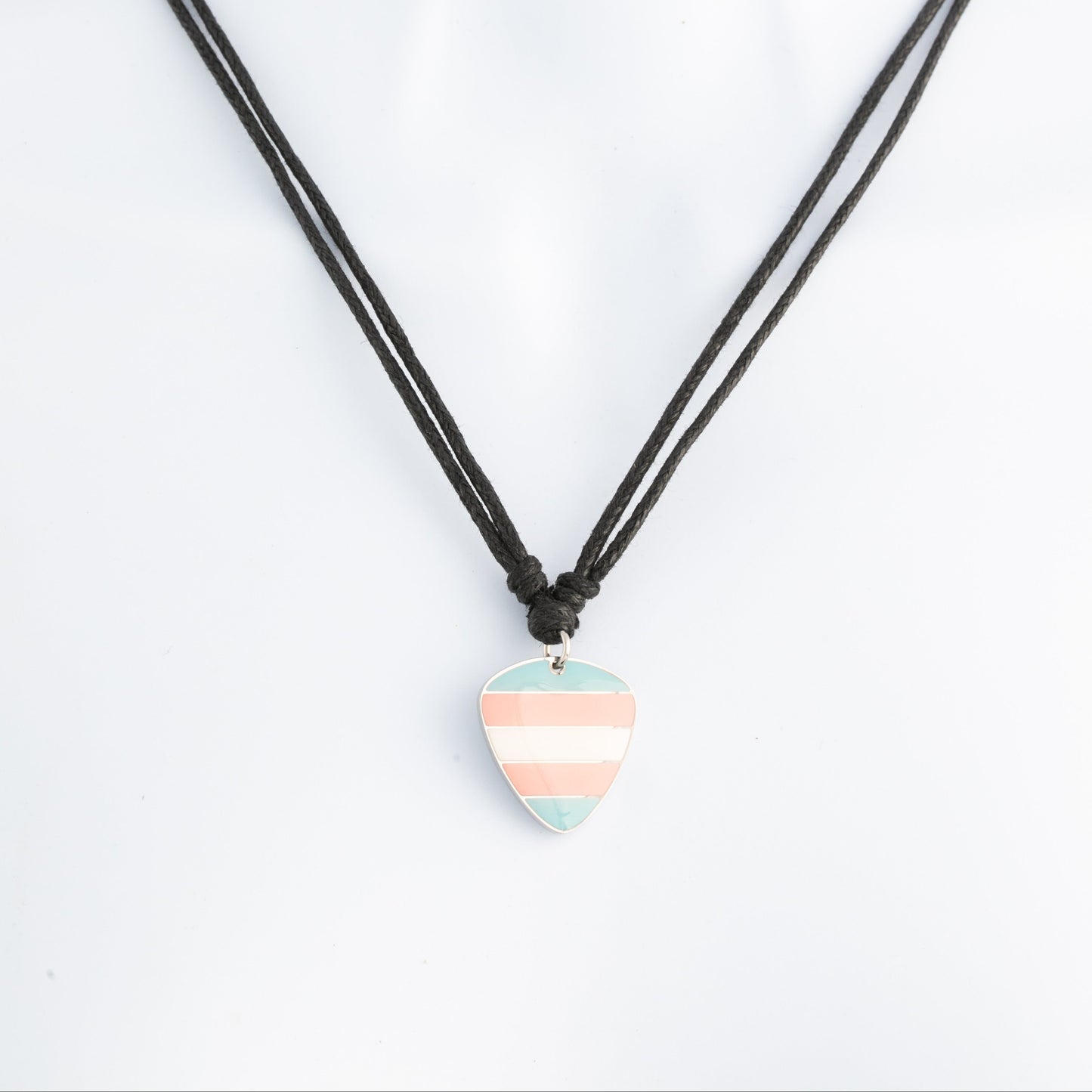 Necklace with a striped trans pride guitar pick pendant on a white background