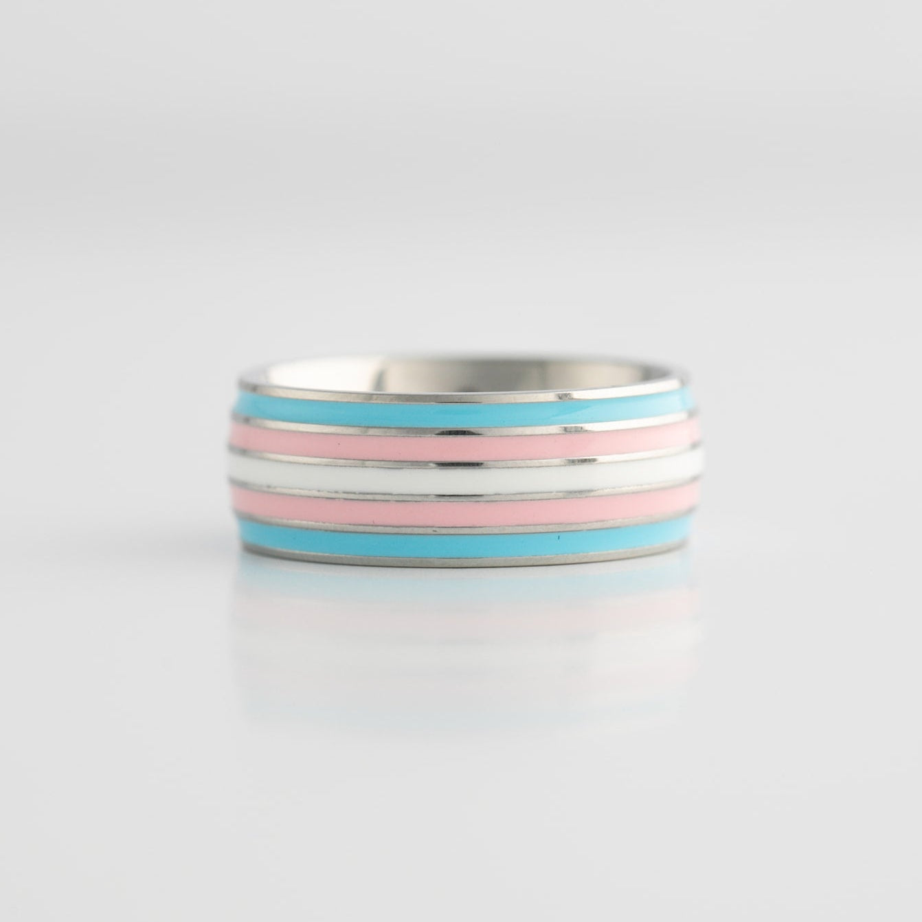 Silver ring with trans pride stripes on a light gray background