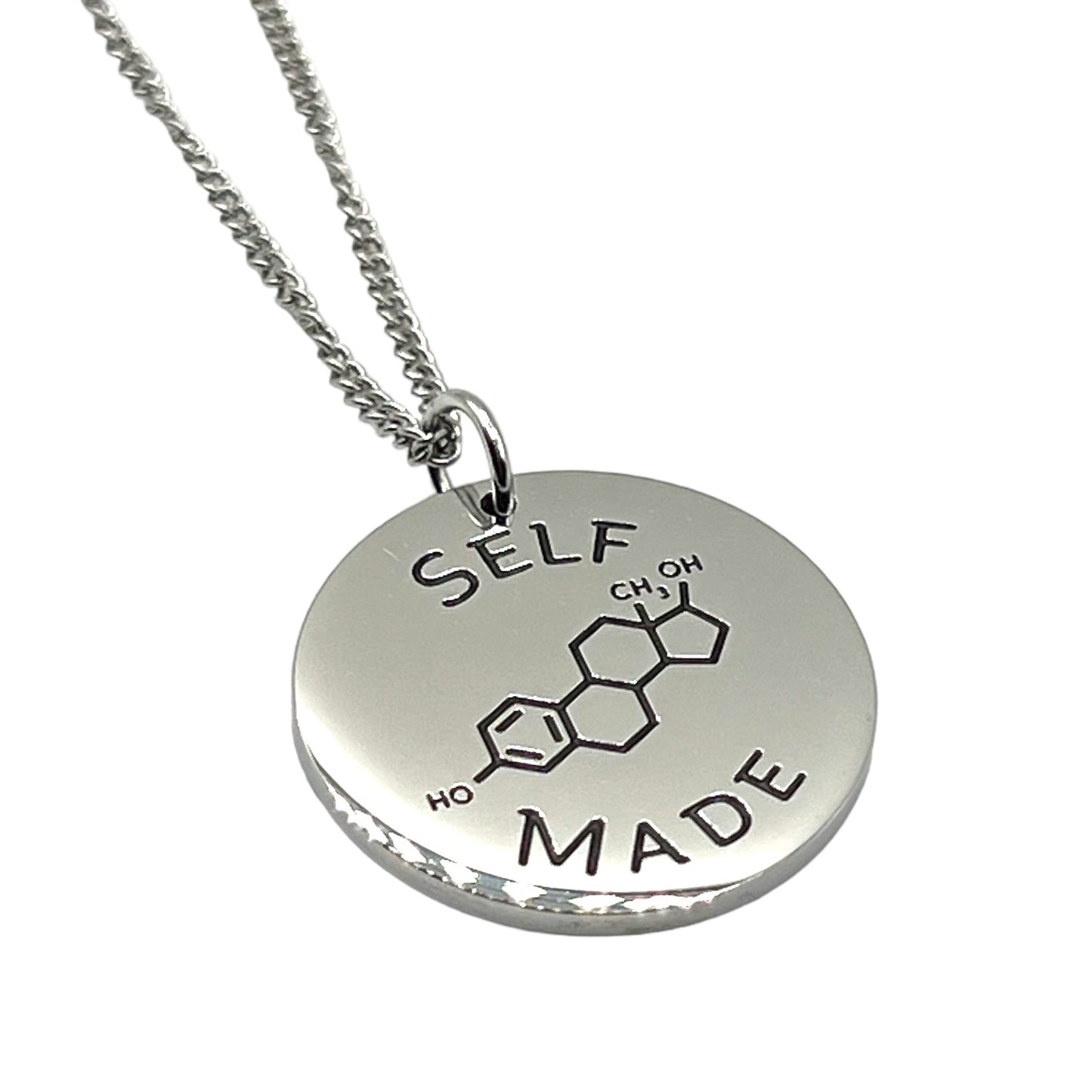 Silver necklace with a round pendant featuring chemical notation for estrogen and 'SELF MADE' text on a white background