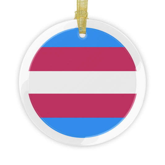 Round clear glass holiday ornament with the transgender pride flag colors in the center and a golden ribbon at top center