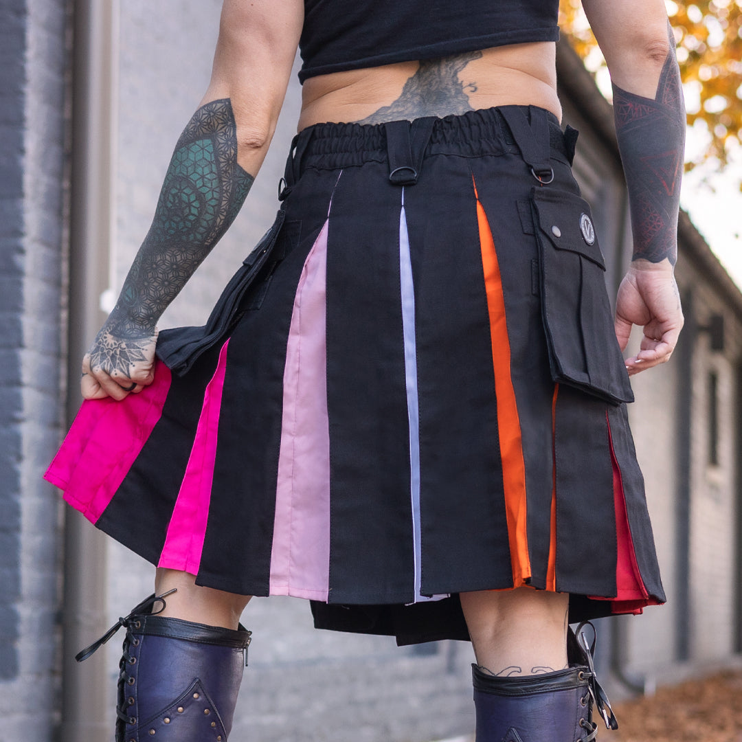 Person wearing a black kilt with colorful stripes, standing against a neutral background.