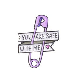 Purple safety-pin lapel pin with 'You are safe with me' text on a white background